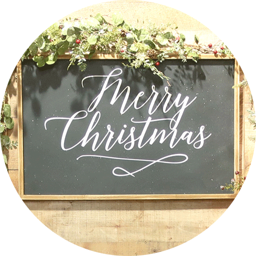 A green Merry Christmas sign with wood border.